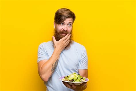 Hombre Pelirrojo Con Barba Larga Y Con Ensalada Sobre Pared Amarilla