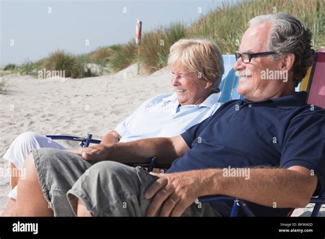 Vieux Couple Assis Sur La Plage Banque De Photographies Et Dimages à