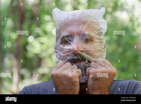 Man With A Plastic Bag On His Head Drowning In The Countryside