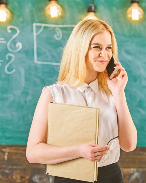 Mujer Con El Libro Que Habla En El Tel Fono M Vil En Sala De Clase