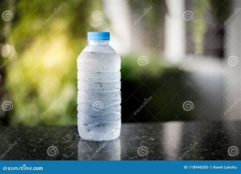 Plastic Bottle Of Drink Water And Reflection On Table With Sunlight At