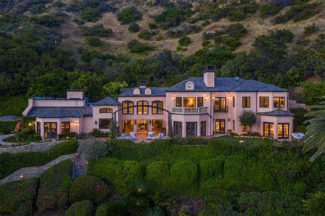 An Aerial View Of A Large Home In The Mountains At Night With Lights On