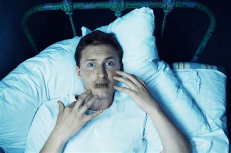 Homme psycho avec sa bouche cousue fermée est allongé dans son lit