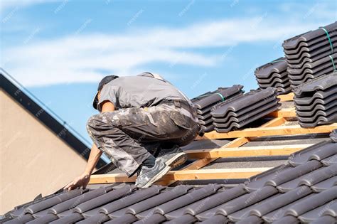 Premium Photo | Installation of ceramic tiles on the roof of the ...