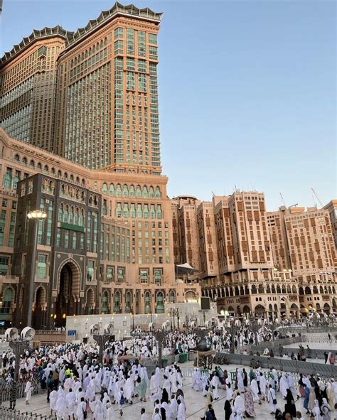 Many People Are Walking Around In Front Of Some Tall Buildings