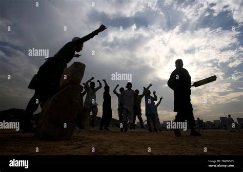 Pakistani children living in slums play cricket in their neighborhood ...