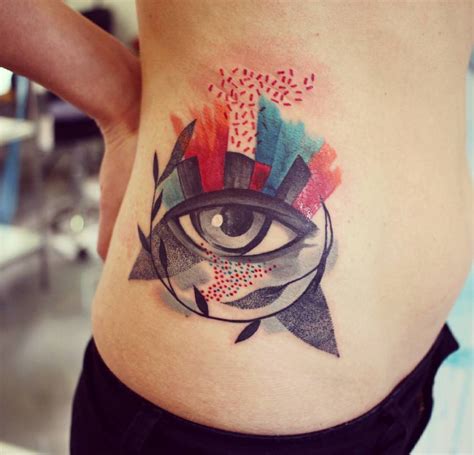 Abstract eye tattoo on the right side of the hip.