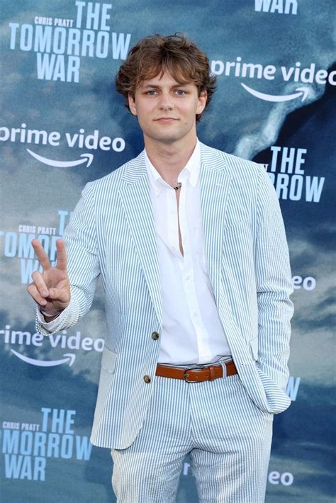 a man in a suit and tie making the peace sign with his hand while ...