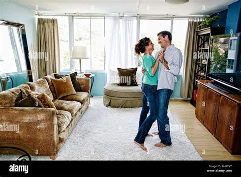 Caucasian couple dancing in living room Stock Photo - Alamy