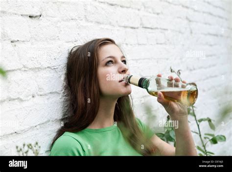 Germany, Berlin, Young woman drinking beer from beer bottle Stock Photo ...