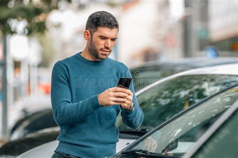 Man With Mobile Phone At Dealership Looking At Cars Stock Image Image