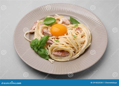 Delicious Pasta Carbonara With Egg Yolk On Light Blue Background