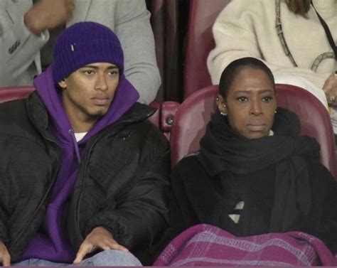 Two People Sitting Next To Each Other In The Stands At A Sporting Event