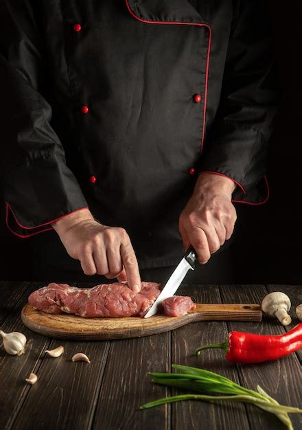 Premium Photo Chef Cuts Raw Beef Meat On A Cutting Board Before