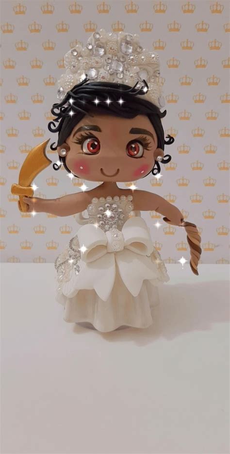 A Small Doll Is Dressed In A White Dress And Holding A Gold Object With