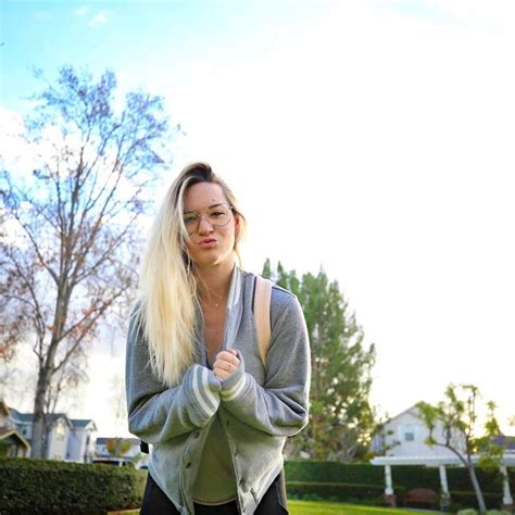 A Woman Is Standing In The Grass With Her Hands On Her Hips And Looking