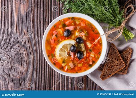 Traditional Russian Meat Soup Solyanka In Bowl On Rustic Wooden Table