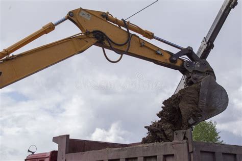 Soil Loading By Excavator Bucket Into The Dump Truck Body Stock Photo