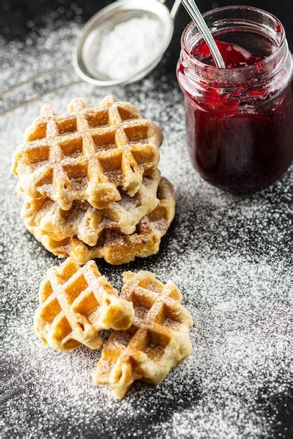 Premium Photo Belgian Waffles Sprinkled With Sugar And Jam On Black Table