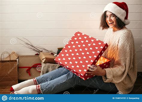 Stylish Happy Girl In Santa Hat Opening Christmas T Box With Magic