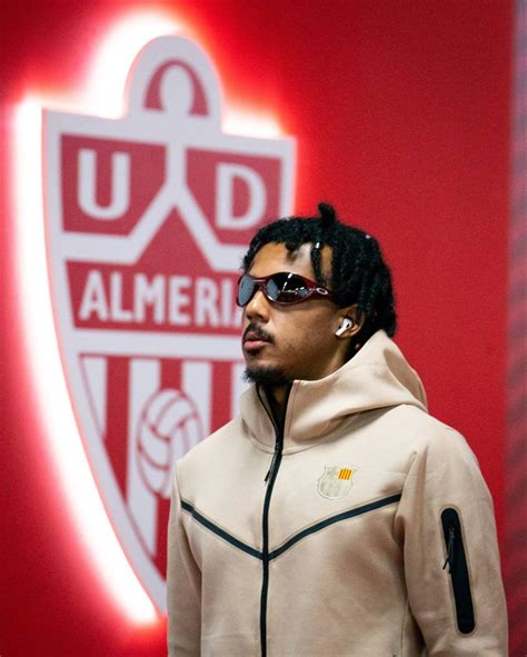 A Man Wearing Sunglasses Standing In Front Of A Red And White Wall With