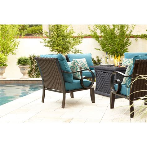 An Outdoor Conversation Set With Blue Cushions Next To A Swimming Pool