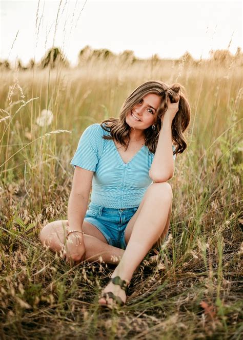 Senior Portrait Sitting In A Wheat Field During Golden Hour Candid And