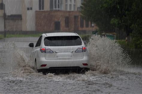 Red Car Rides In Heavy Rain On A Flooded Road Stock Image Image Of