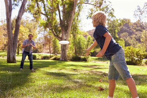 Father And Son Throwing Frisbee In Park Together Stock Photo Dissolve