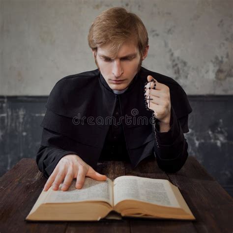 Portrait Of Handsome Young Catholic Priest Praying To God Stock Image