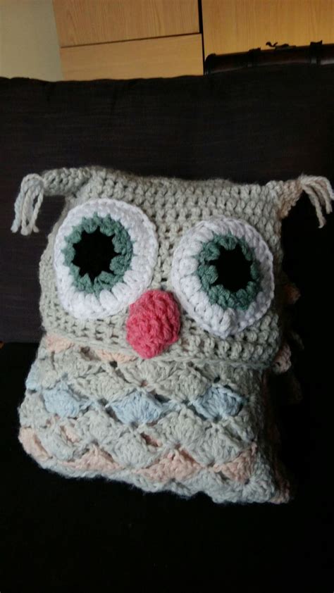 A Crocheted Owl Pillow Sitting On Top Of A Couch