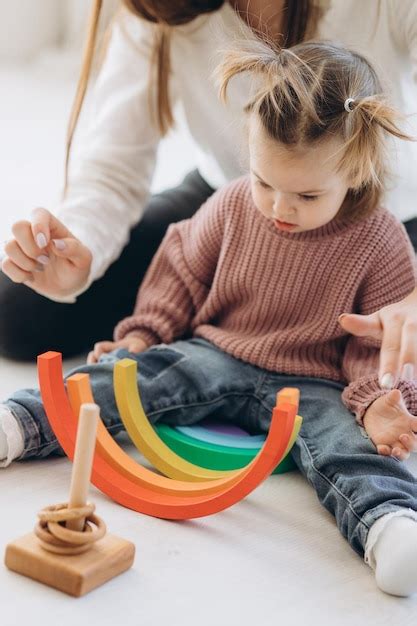 La niña aprende los colores jugando con figuras humanas cilíndricas de