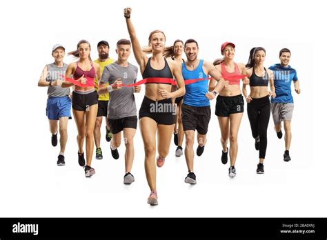 Full length portrait shot of people running a marathon race and a young woman finishing first ...