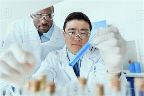 Professional Scientists In White Coats Working Together In Chemical