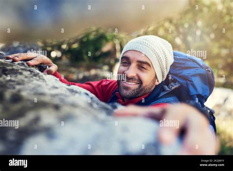 Onwards And Upwards Portrait Of A Happy Hiker Climbing Over Rocks On A