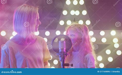 Mom And Daughter Are Engaged In Singing Into Microphone In Karaoke Club