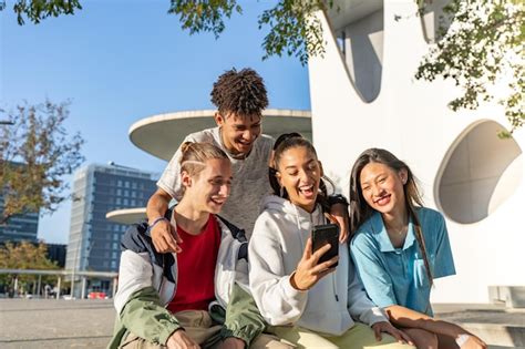 Grupo De Amigos Adolescentes Felizes Olhando Para O Telefone E Rindo Na