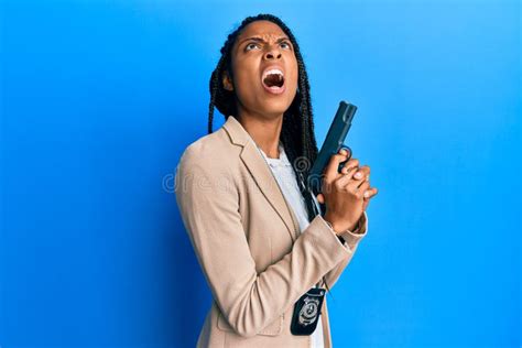 African American Police Woman Holding Gun Angry And Mad Screaming