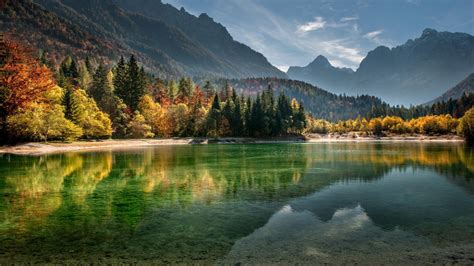 Calm Body Of Water Surrounded With Trees And Mountains During Daytime ...