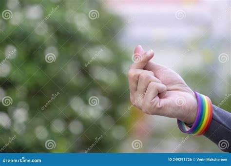 Man Wearing Lgbt Rainbow Wristband Doing Mini Heart Hand Sign For Love