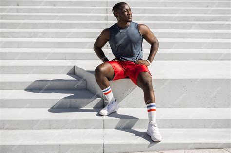 Premium Photo A Man Wearing Red Shorts Sits On A Set Of Stairs