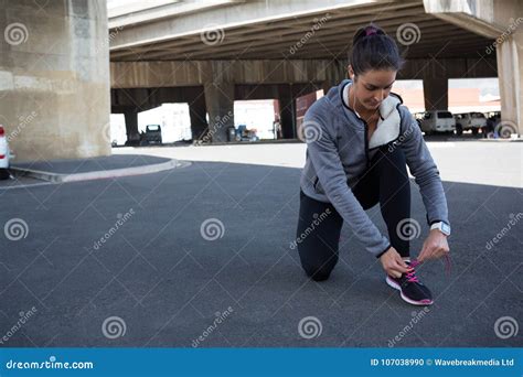 Taqueur Femelle Attachant Ses Dentelles De Chaussure Photo Stock