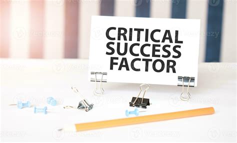 CRITICAL SUCCESS FACTOR sign on paper on white desk with office tools