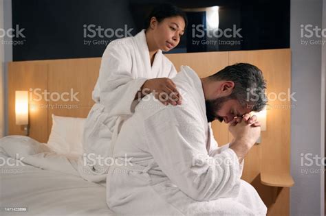 Caring Woman Comforting Her Depressed Boyfriend In Hotel Room Stock