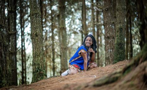 African American Woman Sitting On The Grass In A Forest Laughing Stock