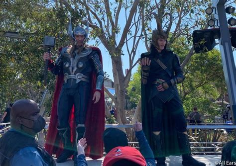 Two Men Dressed As Thor And Loki In Front Of A Crowd At An Outdoor Event