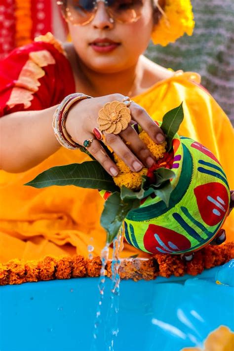 Woman Pouring Water Out Of Colorful Flower Vase · Free Stock Photo