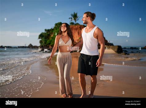 Romantic Couple Strolls On Beach At Sunset Young Man Woman Walk Hand