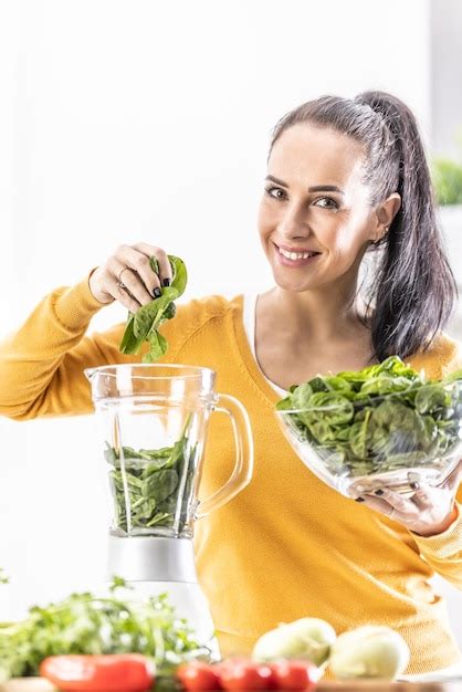 Premium Photo Smiling Woman Making Spinach Smoothie Putting Leaves In