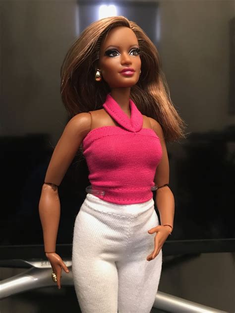 A Barbie Doll Wearing White Pants And A Pink Top With Her Hands On Her Hips